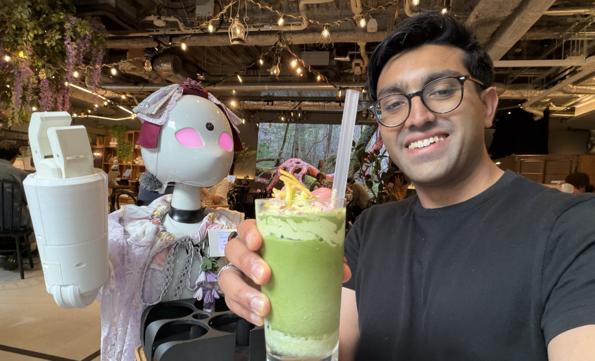 Kunal with a robot server at a cafe in Japan